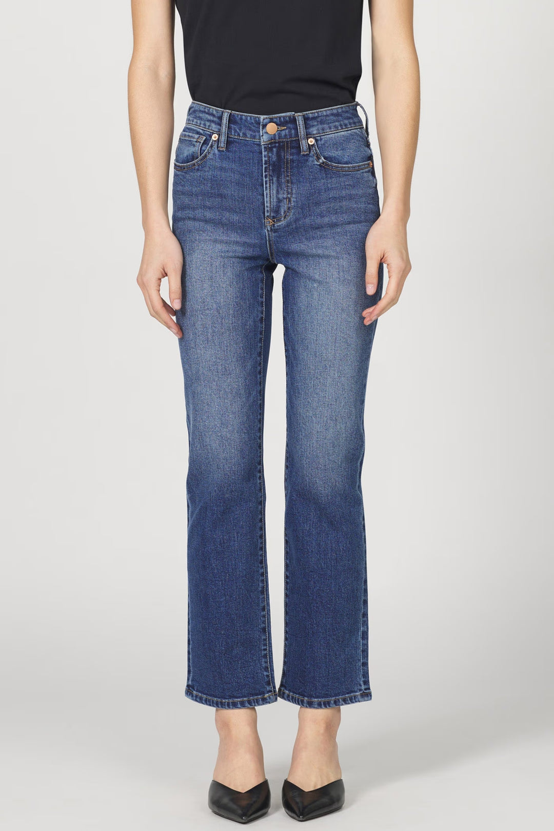 Person wearing blue jeans on a plain background