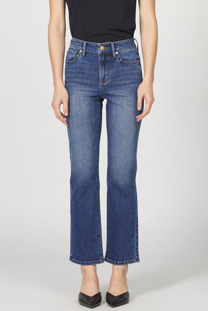 Person wearing blue jeans on a plain background