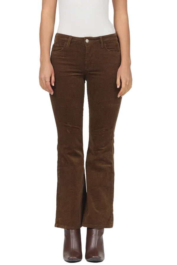A model wearing brown corduroy flare jeans with a white top and brown leather boots, shown from the waist down against a light gray background.