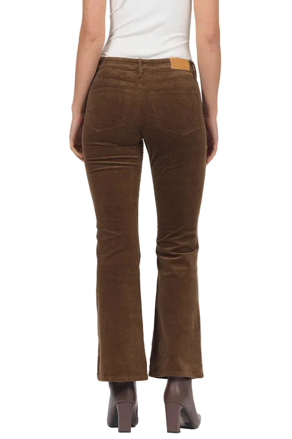 A person shown from the back wearing brown corduroy flare pants, a white top, and brown heeled boots against a light gray studio background.