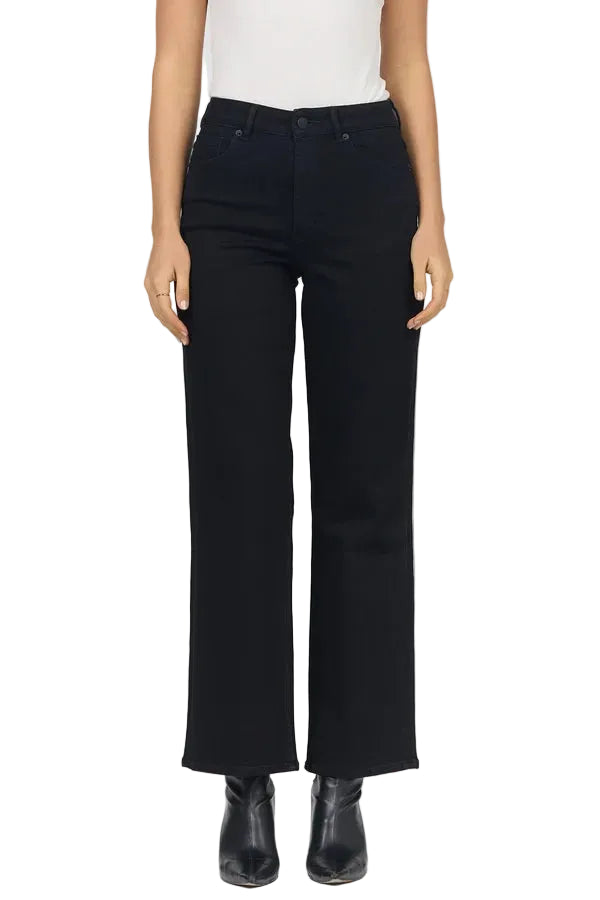 A model wearing black wide-leg cropped jeans, styled with a white sleeveless top and black ankle boots, photographed against a plain white studio background.