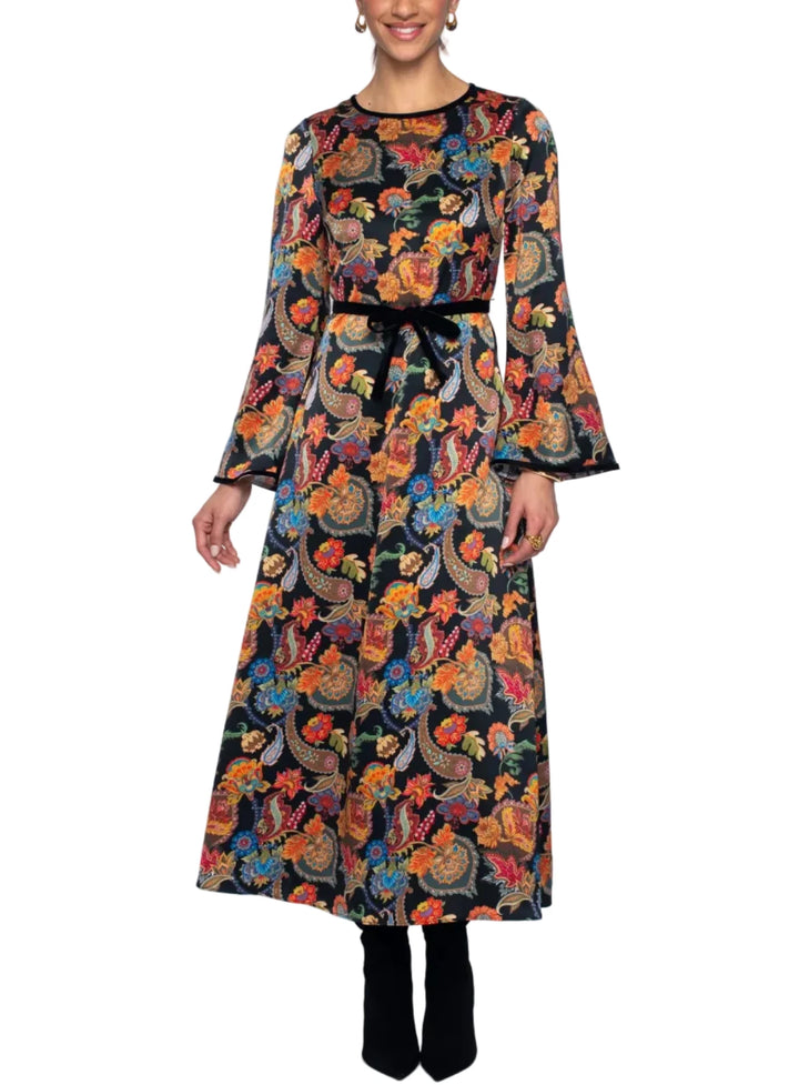 Woman wearing a long, patterned dress on a white background