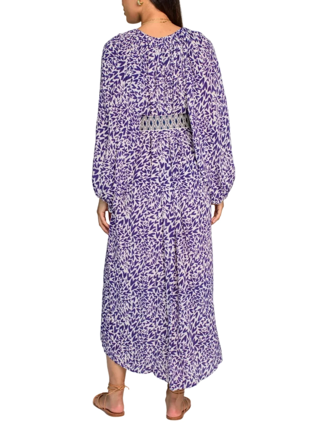 Woman wearing a long purple floral dress on a white background