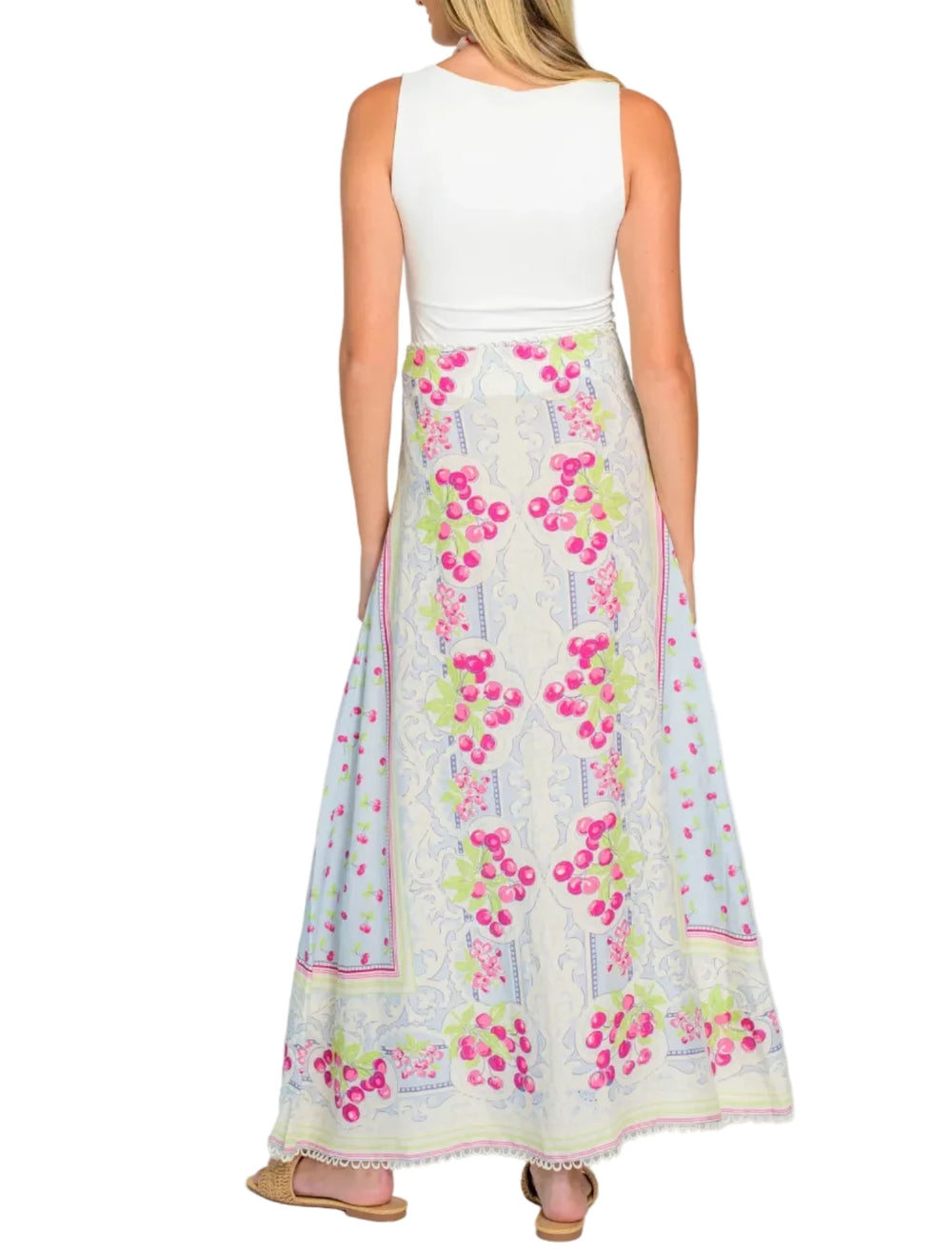 Woman wearing a white sleeveless top and floral skirt on a white background