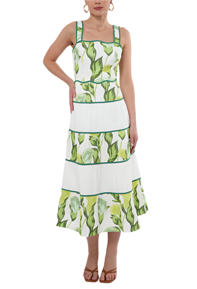 Crafted for elegance, the "Lisha Dress" features a stunning green floral pattern that is perfectly complemented by the contrasting white tiers on the skirt. The scallop neckline and waistline add a touch unique, finishing touch.