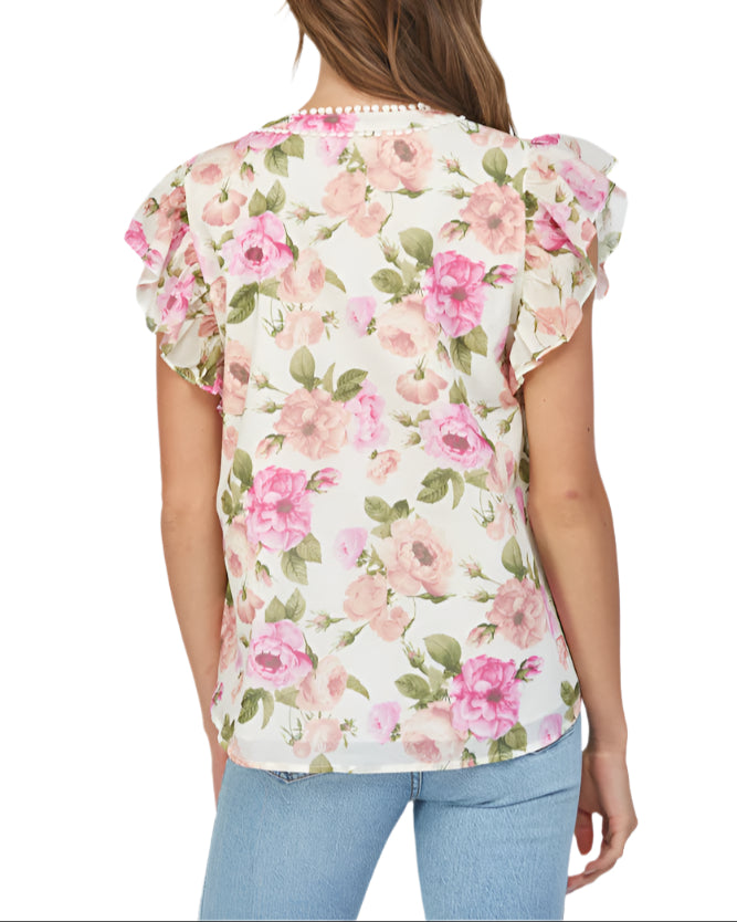 Introducing the Margaret Ivory Multi Top, the perfect addition to your wardrobe! With tuck detailing on the front and flutter sleeves, this top adds a touch of elegance to any outfit.&nbsp;