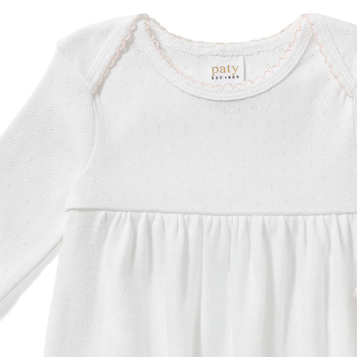 Designed with a softly gathered silhouette and finished with delicate picot trim at the neckline and cuffs, this gown blends comfort with classic detail. The elasticized hem makes diaper changes quick and convenient while keeping baby cozy.