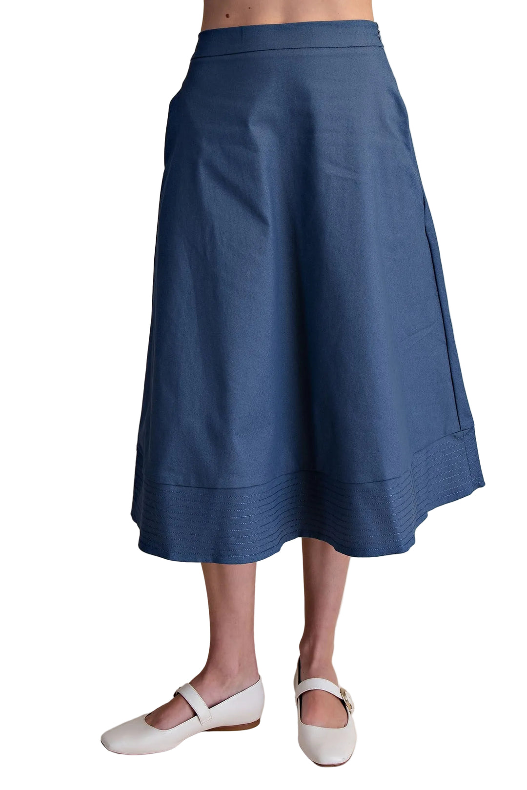 The Gloria A-Line Midi Skirt in Indigo combines timeless elegance with everyday wearability. This flattering silhouette skims the body with a graceful A-line cut that elongates your frame, while the midi length offers versatile styling for any occasion. Crafted with precision, the stitch hem detail adds a refined finish that keeps its shape through countless wears. The rich indigo hue pairs effortlessly with neutral tops or bold prints, making it a wardrobe essential that transitions seamlessly from office 