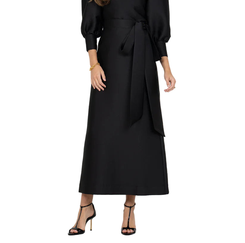 The Audrey Skirt in Midnight is a timeless wrap silhouette designed with a high waist and a tacked side belt that ties into a voluminous bow. Crafted in a structured fabric with a subtle sheen, this maxi-length style drapes with polish and ease. A versatile piece for your capsule wardrobe, it pairs effortlessly with everything from statement tops to sleek knits, making it a refined choice for elevated dressing this season.

Details:

Hidden side zip closure
Side tacked self-tying bow
High waisted silhouette