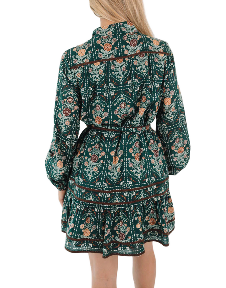 Step into autumn style with this hunter green multi-print dress, featuring long sleeves, a button-up neckline, & an adjustable tie belt for a flattering fit. Accented with brown embroidery trim detail, it channels effortless charm with a hint of ranch lifestyle. The perfect piece for autumn outings, weekend plans, & golden-hour strolls!