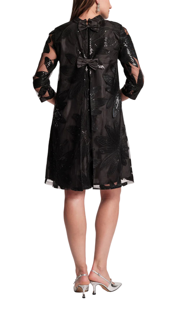 The Diplomat Mini is back for the holiday season, bringing with it all the bows, pleats, and feminine charm you love. This time, it arrives with a festive update: sheer mesh sleeves adorned with delicate floral sequin embroidery, scattered like midnight stars. Equal parts timeless and luminous, it’s a party-ready piece destined to shine year after year.