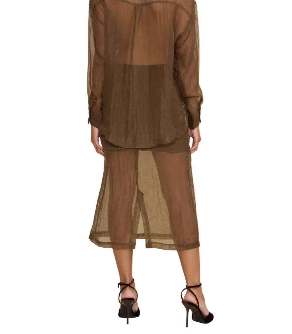 A woman shown from the back wearing a sheer brown long-sleeve button-up shirt and matching sheer midi skirt over a brown underlayer, paired with black high-heeled sandals, against a solid beige studio background.
