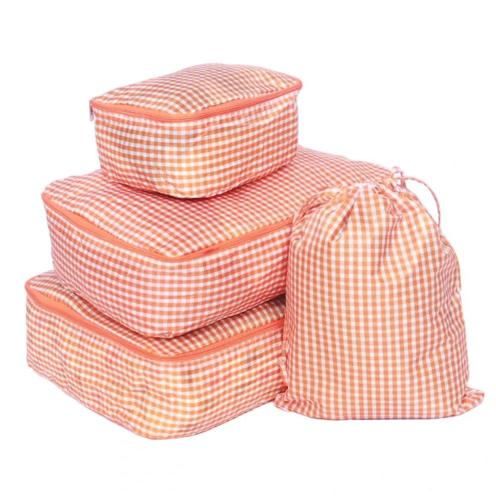 Set of orange checkered packing cubes on a white background