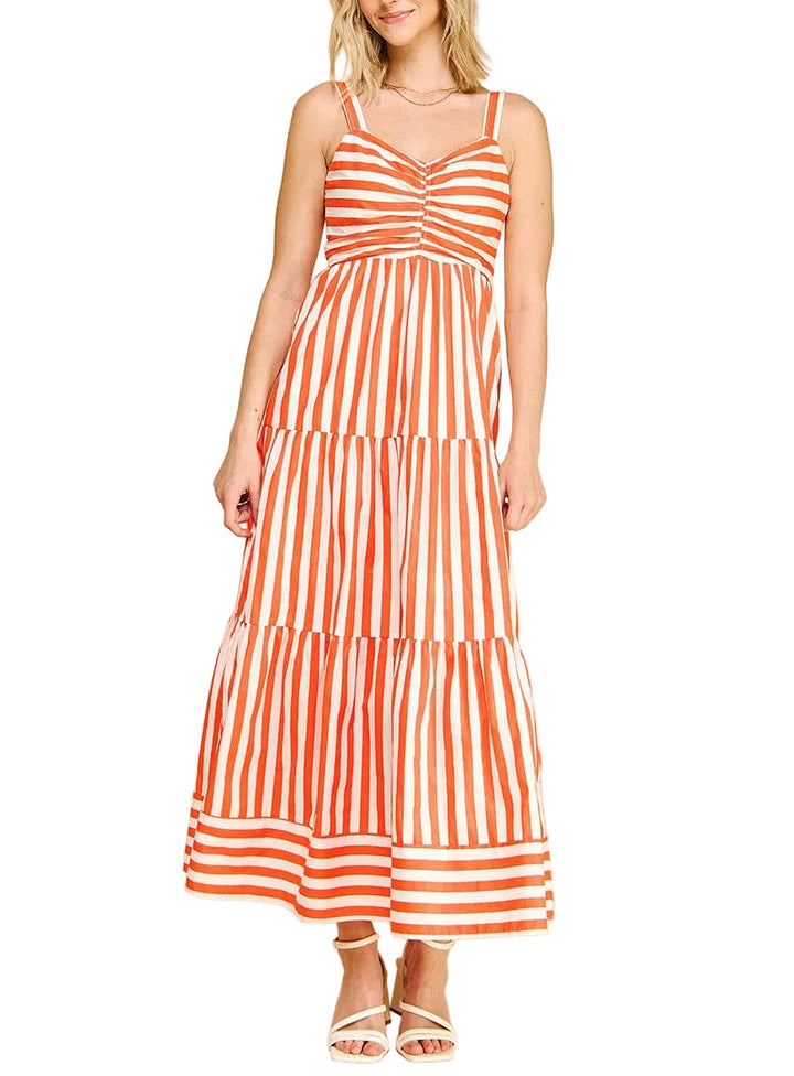 Woman wearing an orange and white striped dress on a beige background