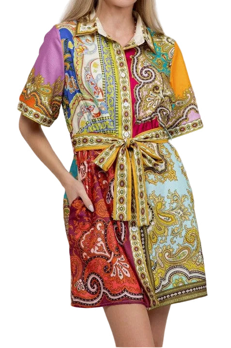 Woman wearing a colorful patterned dress against a plain background