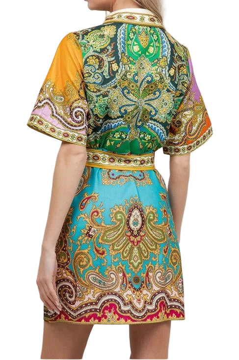 Woman wearing a colorful patterned dress with a plain background