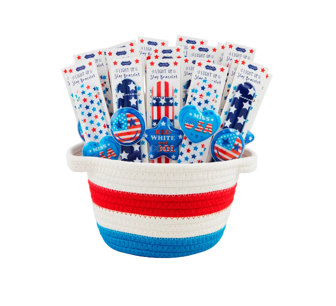 Basket with patriotic-themed items including bracelets and a plush toy on a white background