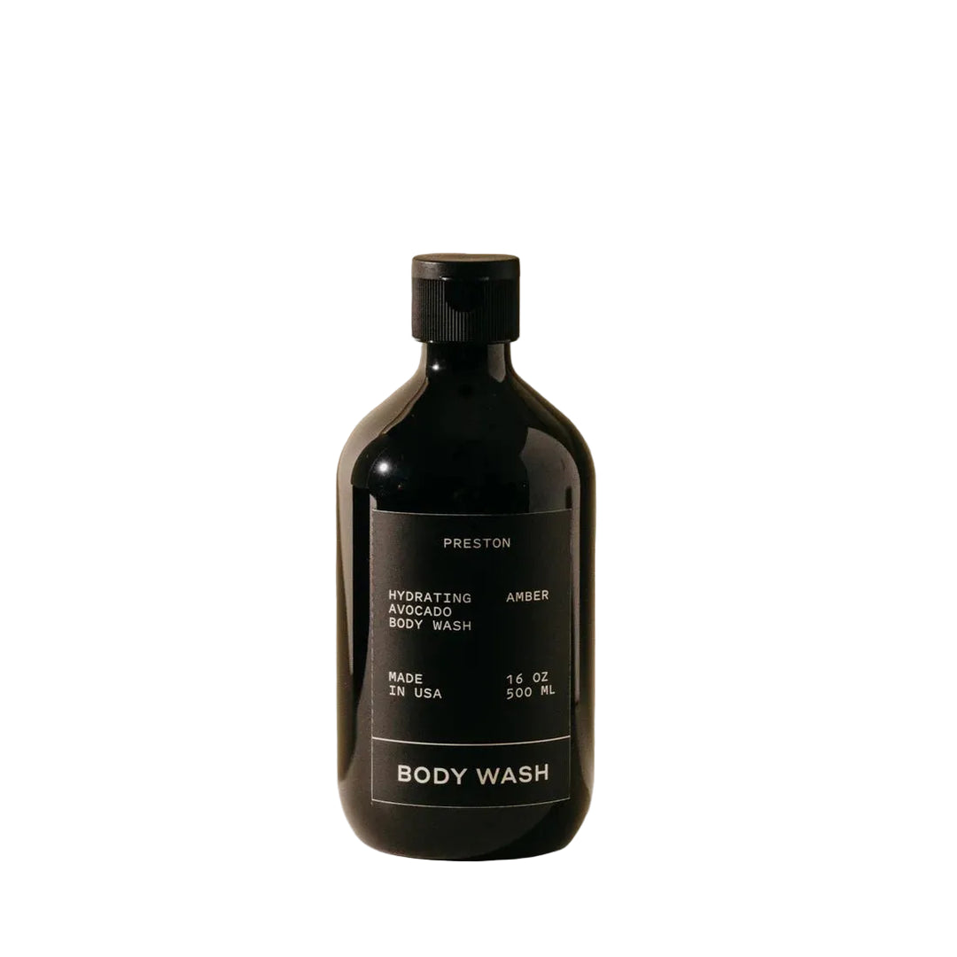 Black body wash bottle with label on a beige background