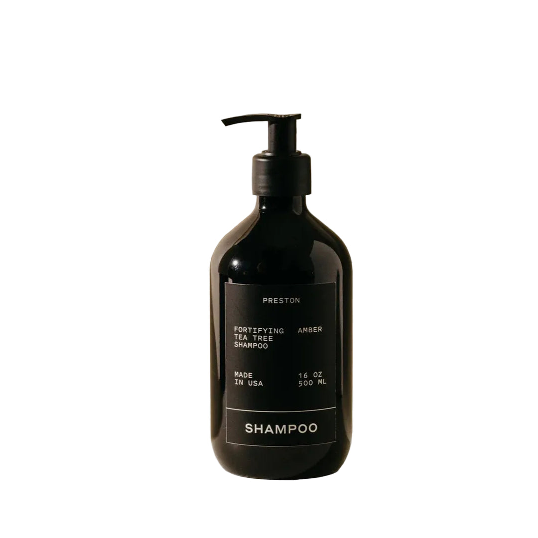 Black shampoo bottle with pump on a beige background