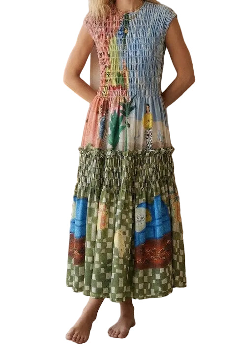 Woman wearing a colorful dress standing in a room with a cactus plant and wooden chair.