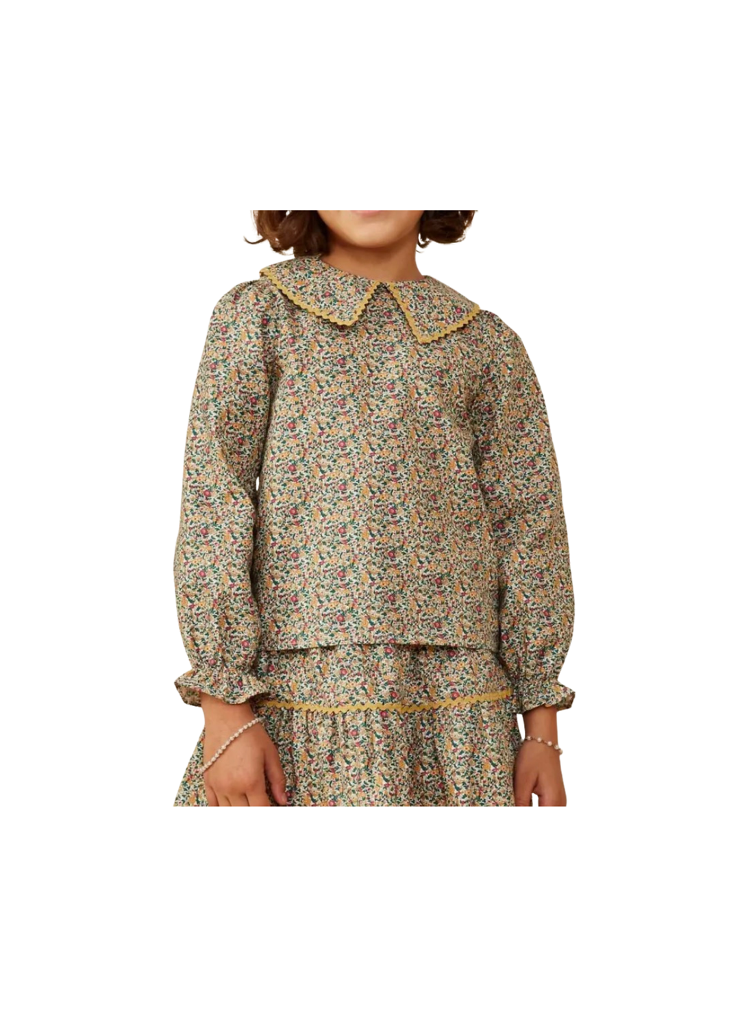 A child wearing a long-sleeve floral print top with a large Peter Pan collar and gold trim, paired with a matching skirt, shown against a plain white background.