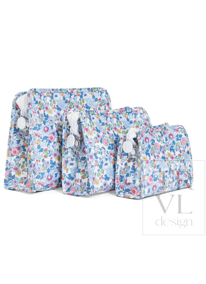 Set of floral-patterned bags with pom-pom handles on a white background, featuring the brand &