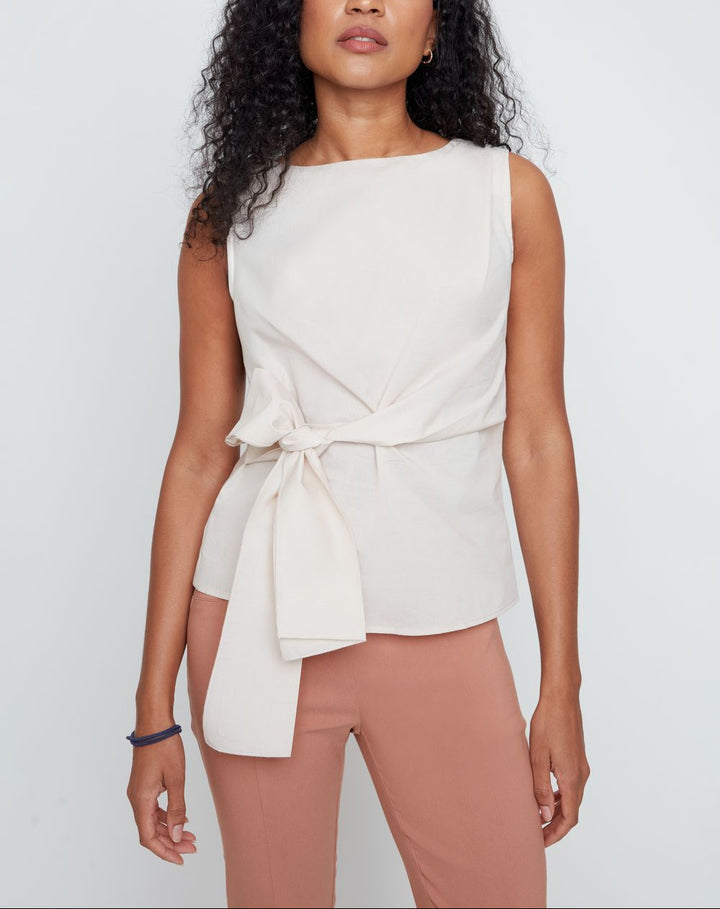 The Marci Sleeveless Blouse is your new go-to for effortless style with a twist! This breezy sleeveless design features an adjustable tie at the waist that lets you cinch, knot, or drape it however you like. Perfect for layering over a tee or wearing solo, it&