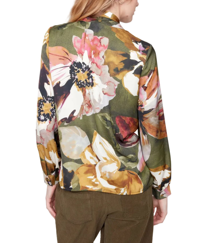 Woman wearing a floral jacket with a plain background