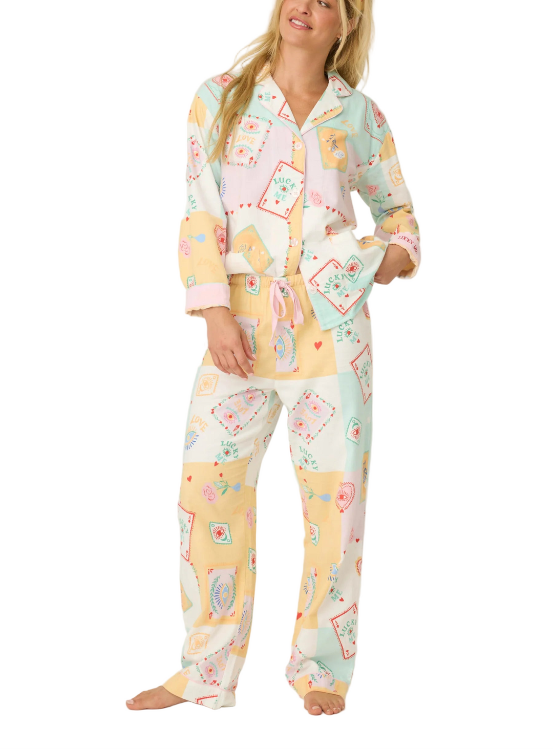Sleep, lounge, repeat in this dreamy three-piece flannel set with a whimsical, luck-inspired twist. Made from soft cotton in a classic twill weave, it includes a button-up shirt, relaxed-fit pants, and a matching headband. The patchwork-style design blends soft ivory, pastel mint, peach, and lilac, scattered with playful motifs—lucky playing cards, eye talismans, radiant hearts, blooming flowers, and “Lucky Me” script—for a look that’s as charming as it is cozy.