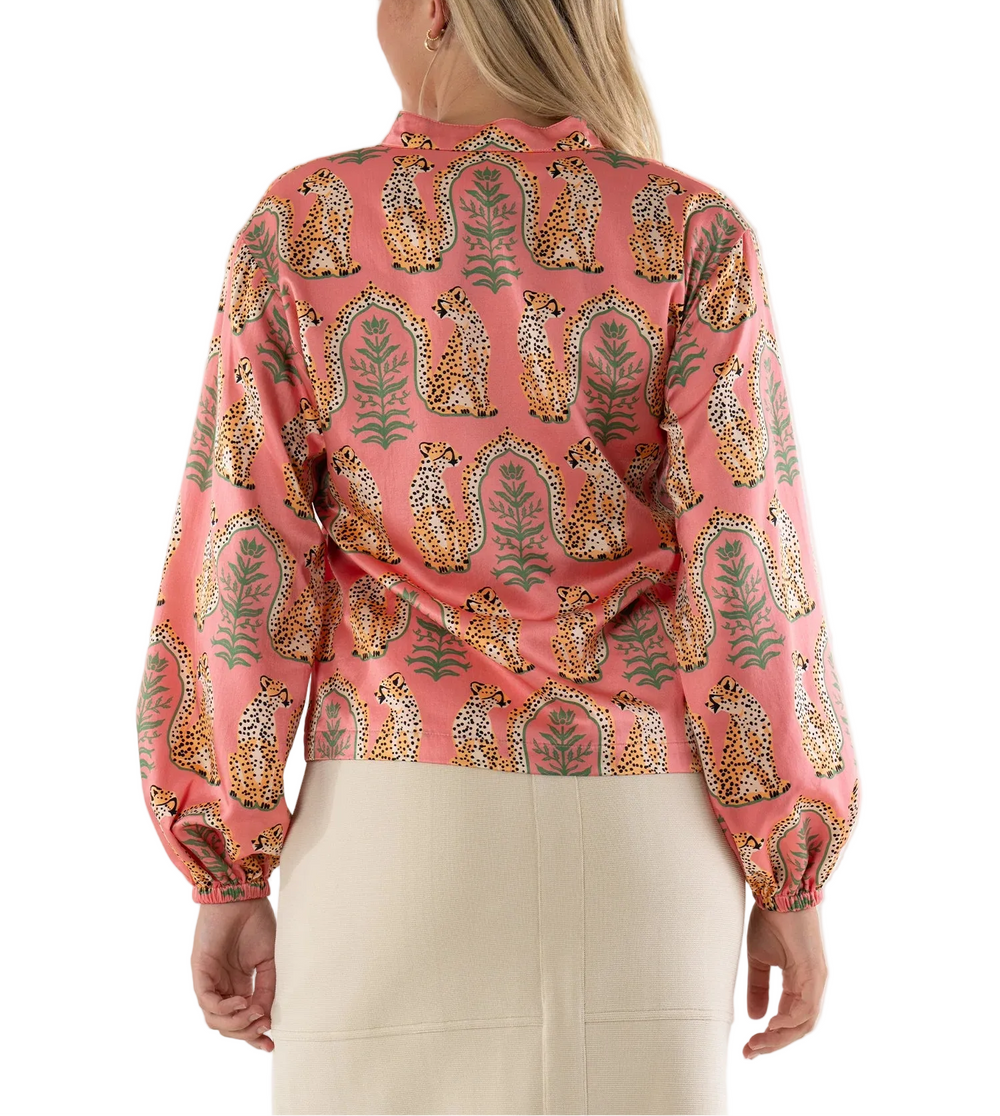 The Lolli Top in Cabana Cat is a statement piece designed with a mandarin-style collar, softly gathered blouson sleeves with elastic cuffs, and an easy silhouette. The playful Cabana Cat motif pairs spotted cheetahs with delicate greenery, creating a whimsical yet artful print that feels both fresh and intentional. Effortless in shape but rich in personality, this style transitions seamlessly from daytime luncheons to spring soirées, offering a distinctive charm.