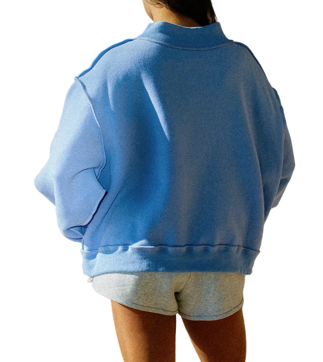Person wearing a blue sweatshirt and gray shorts