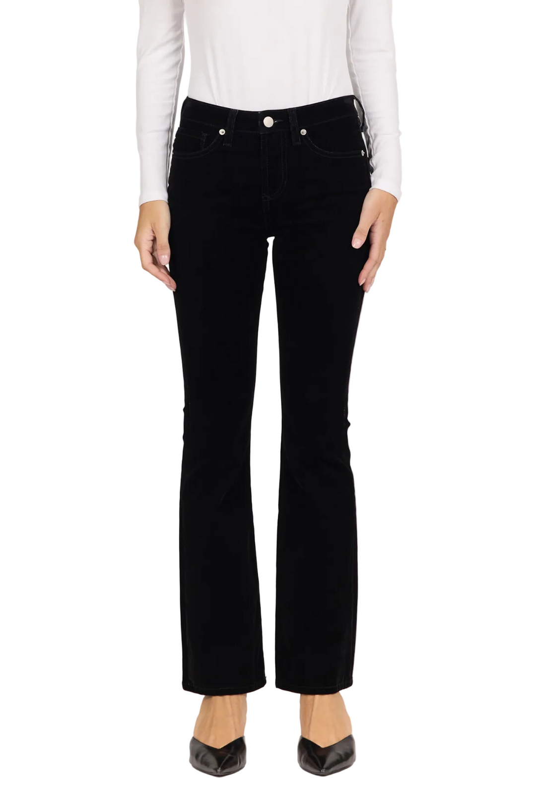 Black flared jeans worn by a model, paired with a white long-sleeve top and black pointed-toe heels, shown against a plain light gray studio background.