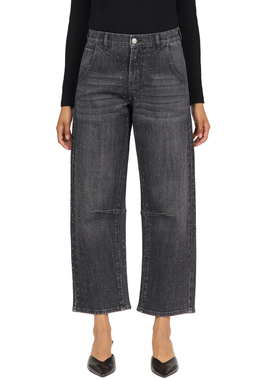 A model wearing a pair of wide-leg cropped jeans in dark gray washed denim, styled with a black long-sleeve top and black pointed-toe heels against a plain white studio background.