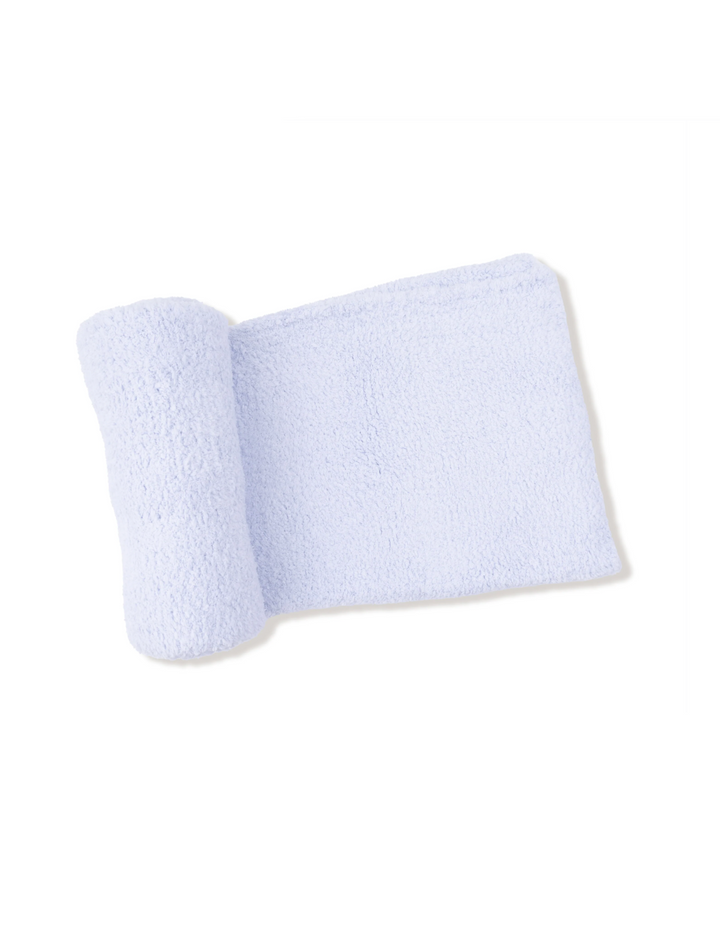 A light blue textured baby wrap or blanket, partially rolled, displayed on a white background with a dark footer containing website text.