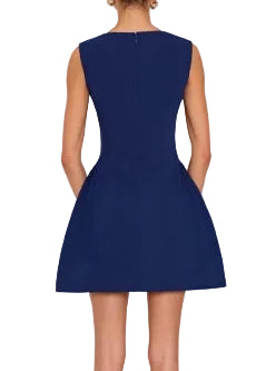 The Leora Dress in navy blue. Scoop neck mini dress with tea cup skirt which gathers at the hips. Concealed zipper at center back and lined throughout.