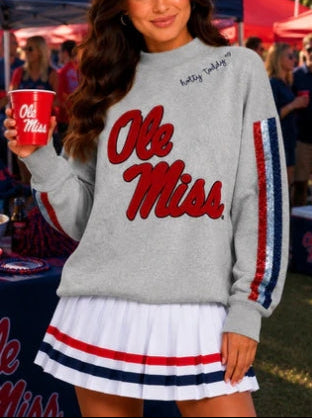 This is an Officially Licensed Collegiate Product
Soft gray mock neck sweatshirt featuring a bold Alabama elephant and “A” appliqué for a classic collegiate look
Eye catching sequin stripe detailing down each sleeve adds just the right amount of sparkle and contrast
Crafted from soft cotton Terry sweatshirt material 
Material: 80% Cotton, 20% Polyester
STYLE NOTE: This sweatshirt is made to fit oversized. You should purchase your normal size if you want the oversized look and fit. If you want a more fitted 