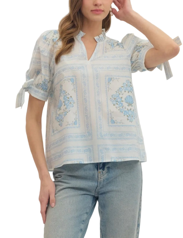 Printed short puff sleeve top featuring ruffle band collar V-neck. Self-tie detail at sleeves. Unlined. Woven. Non-sheer. Lightweight.
