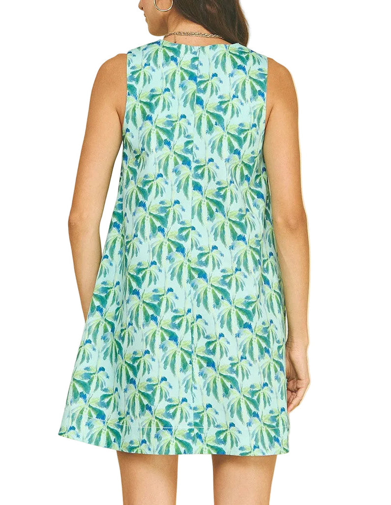 Woman wearing a sleeveless dress with a leaf pattern on a beige background