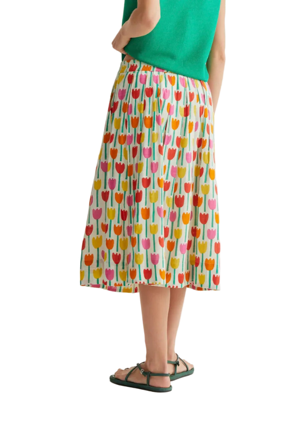Person wearing a colorful patterned skirt with a plain background
