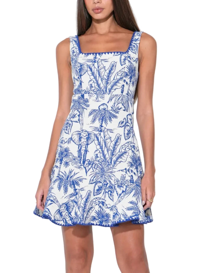 Rendered in a stunning Blue and White palette, the Ximena dress features a rich jacquard weave that provides a tactile, dimensional quality to the fabric. The intricate pattern—often reminiscent of classic porcelain or sun-drenched tiles—elevates the mini silhouette into something truly special.
