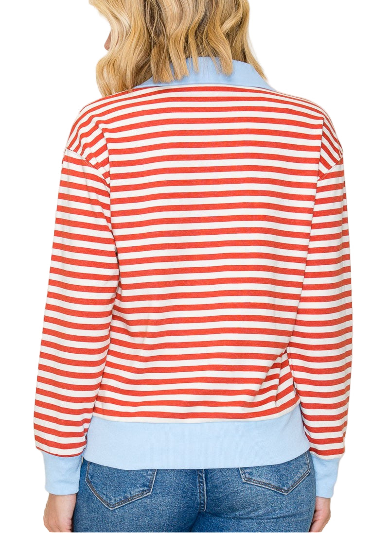 Person wearing a red and white striped shirt with light blue trim on a plain background