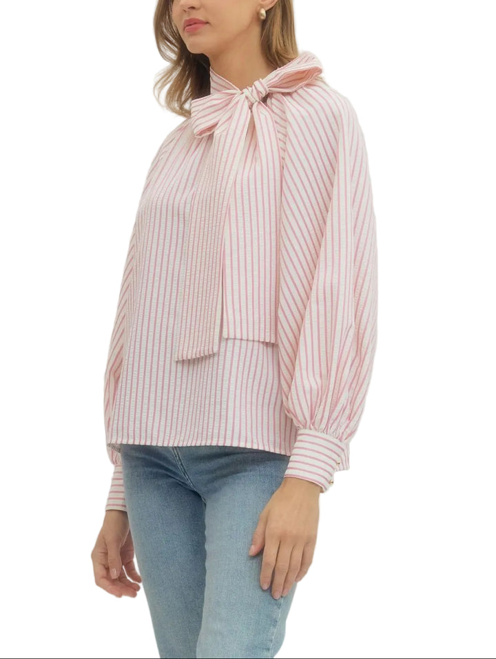 Elevate your everyday style with the Zoey Striped Long Sleeve Blouse, where timeless stripes meet modern charm. This versatile piece features a playful tie neck bow that adds instant personality to any outfit—dress it up for the office or down for weekend adventures. The long sleeves offer coverage and sophistication, while the classic striped pattern keeps things fresh and fun. Perfect for layering or wearing solo, this blouse is your new go-to for effortless style that works as hard as you do.