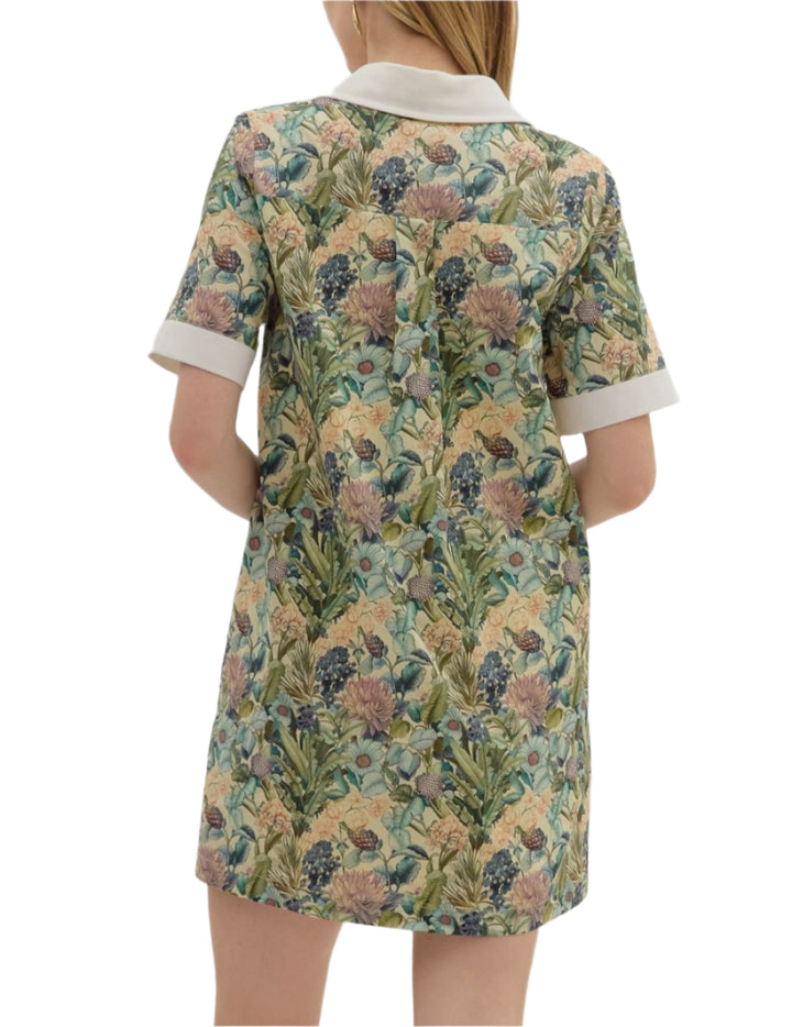 Floral print short sleeve mini dress featuring contrast accent collar button closure and band detail. Pockets at sides. Lined. Woven. Non-sheer. Lightweight.