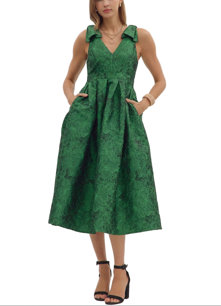 Floral jacquard sleeveless midi dress featuring bow accent at shoulder straps and pleated skirt. Zip closure at back. Side pockets. Unlined. Woven. Non-sheer. Lightweight.