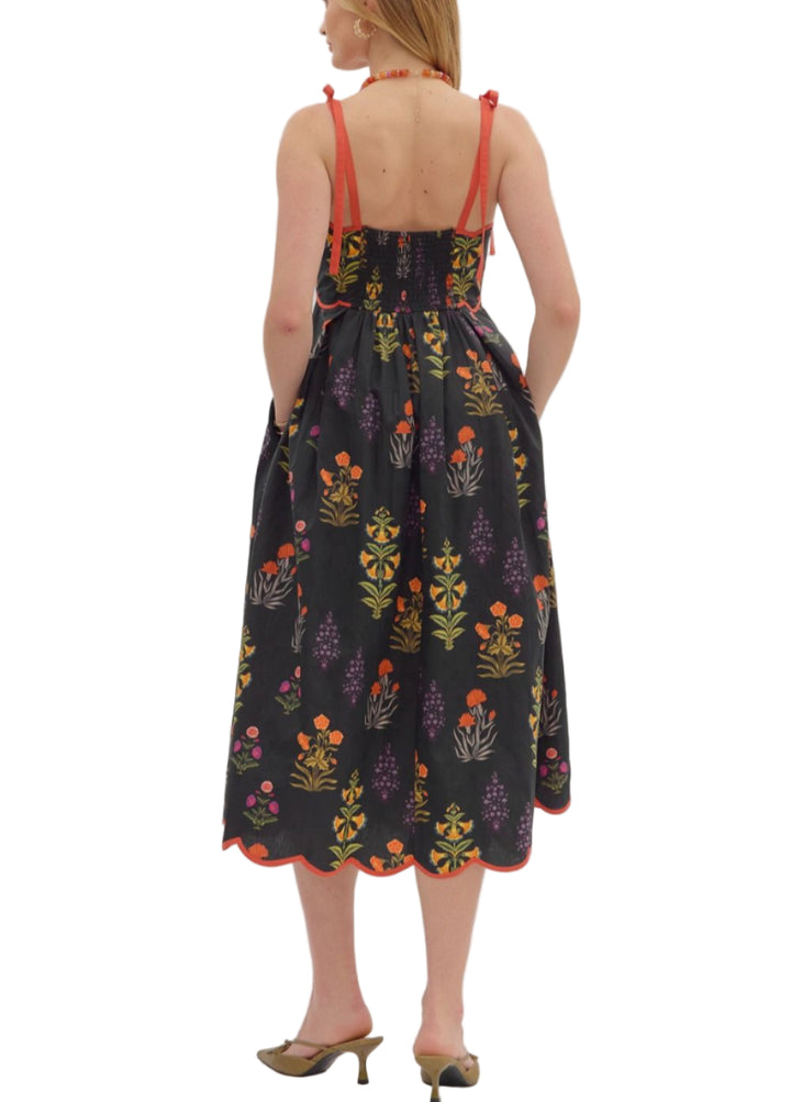 Floral print tie strap midi dress featuring scalloped straight neckline with binding detail and pleated waist. Smocked back. Side pockets. Lined. Woven. Non-sheer. Lightweight.