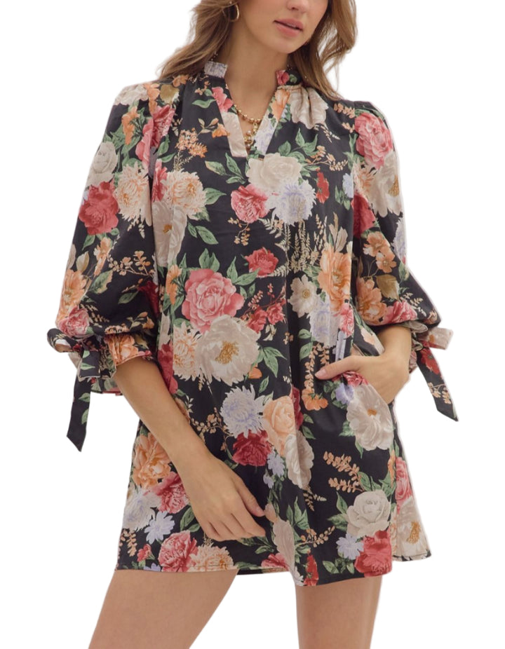 Floral print ¾ bubble sleeve mini dress featuring fixed bow accent ruffle V-neck. Pockets at sides. Lined. Woven. Non-sheer. Lightweight.

