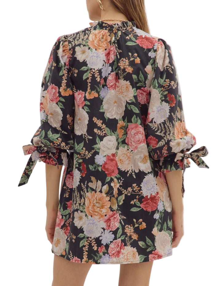 Floral print ¾ bubble sleeve mini dress featuring fixed bow accent ruffle V-neck. Pockets at sides. Lined. Woven. Non-sheer. Lightweight.
