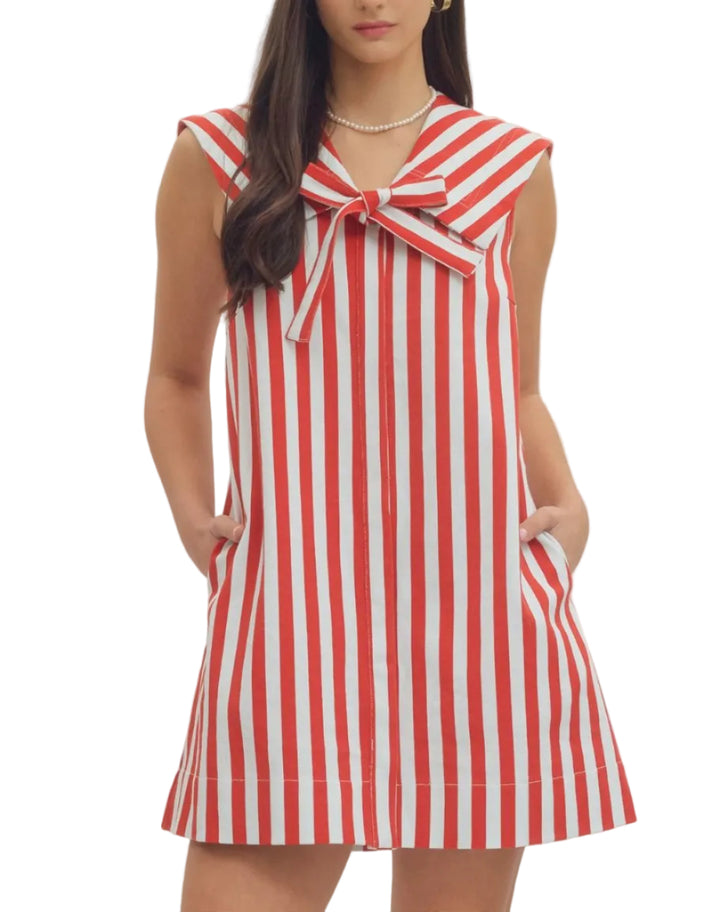 Striped sleeveless mini dress featuring oversized sailor collar with self-tie bow detail. Side pockets. Unlined. Woven. Non-sheer. Lightweight.
