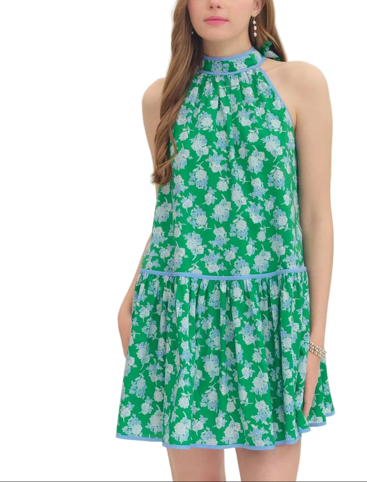 Floral print sleeveless mini dress featuring self-tie halter neckline. Drop waist seam. Contrast binding detail. Side pockets. Lined. Woven. Non-sheer. Lightweight.