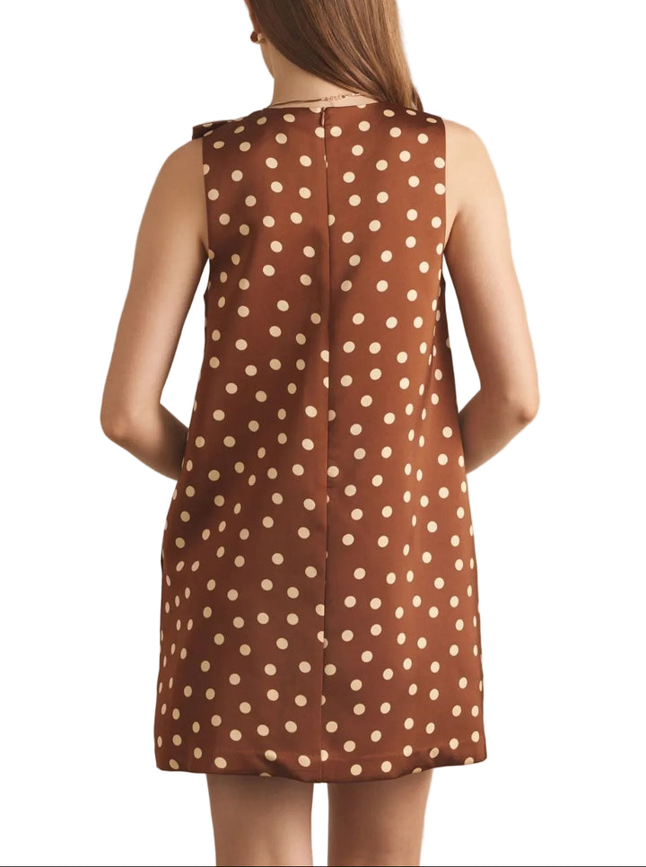 The Aria Polka Dot Short Dress brings effortless charm to your warm-weather wardrobe. This sleeveless design features a classic polka dot pattern in rich brown tones, perfect for creating a vintage-inspired look. The distinctive ribbon neckline adds an elegant finishing touch, offering a flattering silhouette that transitions seamlessly from casual daytime wear to evening occasions. Lightweight and comfortable, this dress is ideal for layering or wearing solo during warmer months.